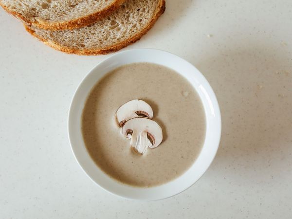 A bowl of soup with sliced bread for lunch.